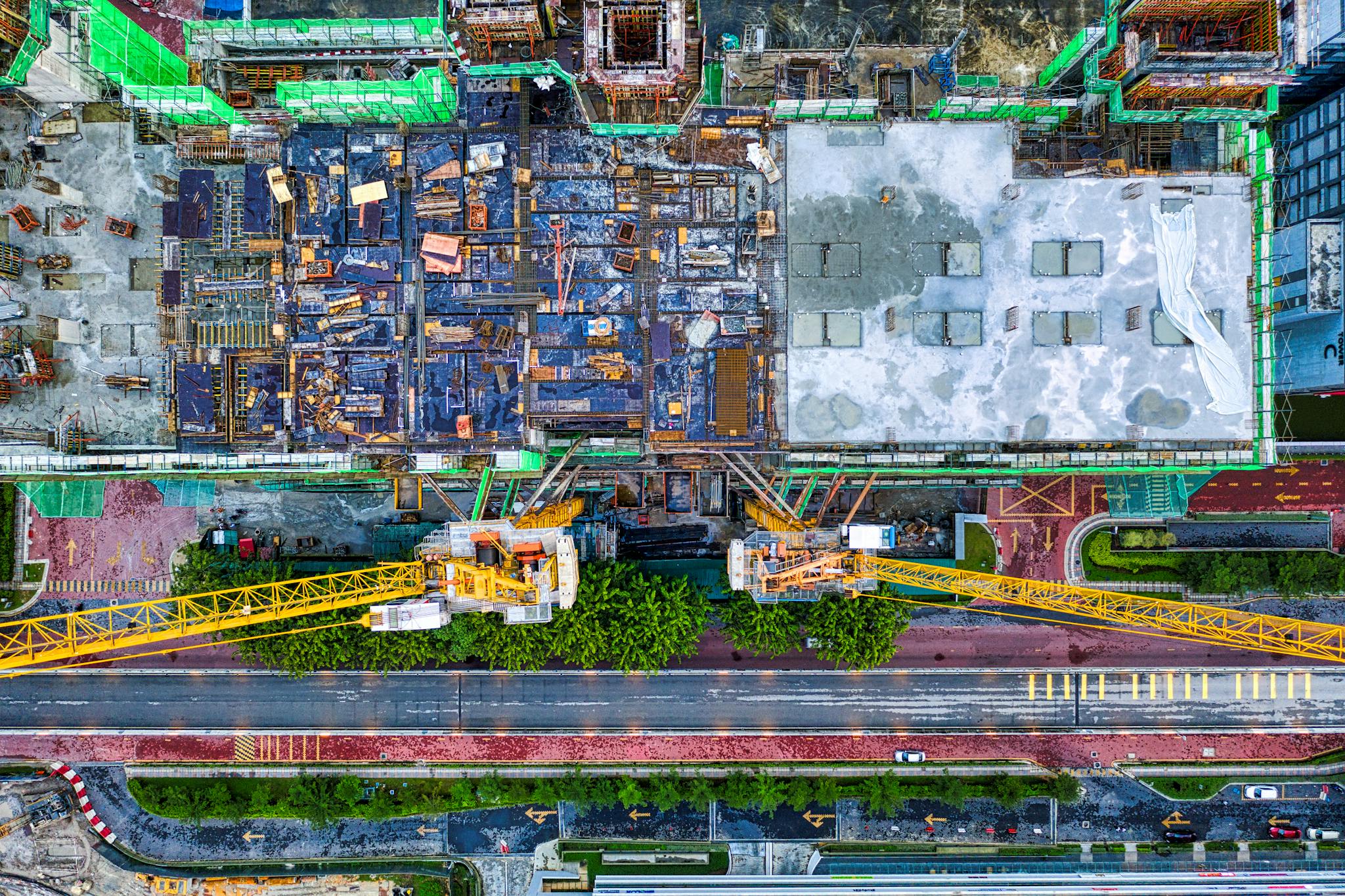 High-angle aerial view of a construction site with cranes in Petaling Jaya, Malaysia.
