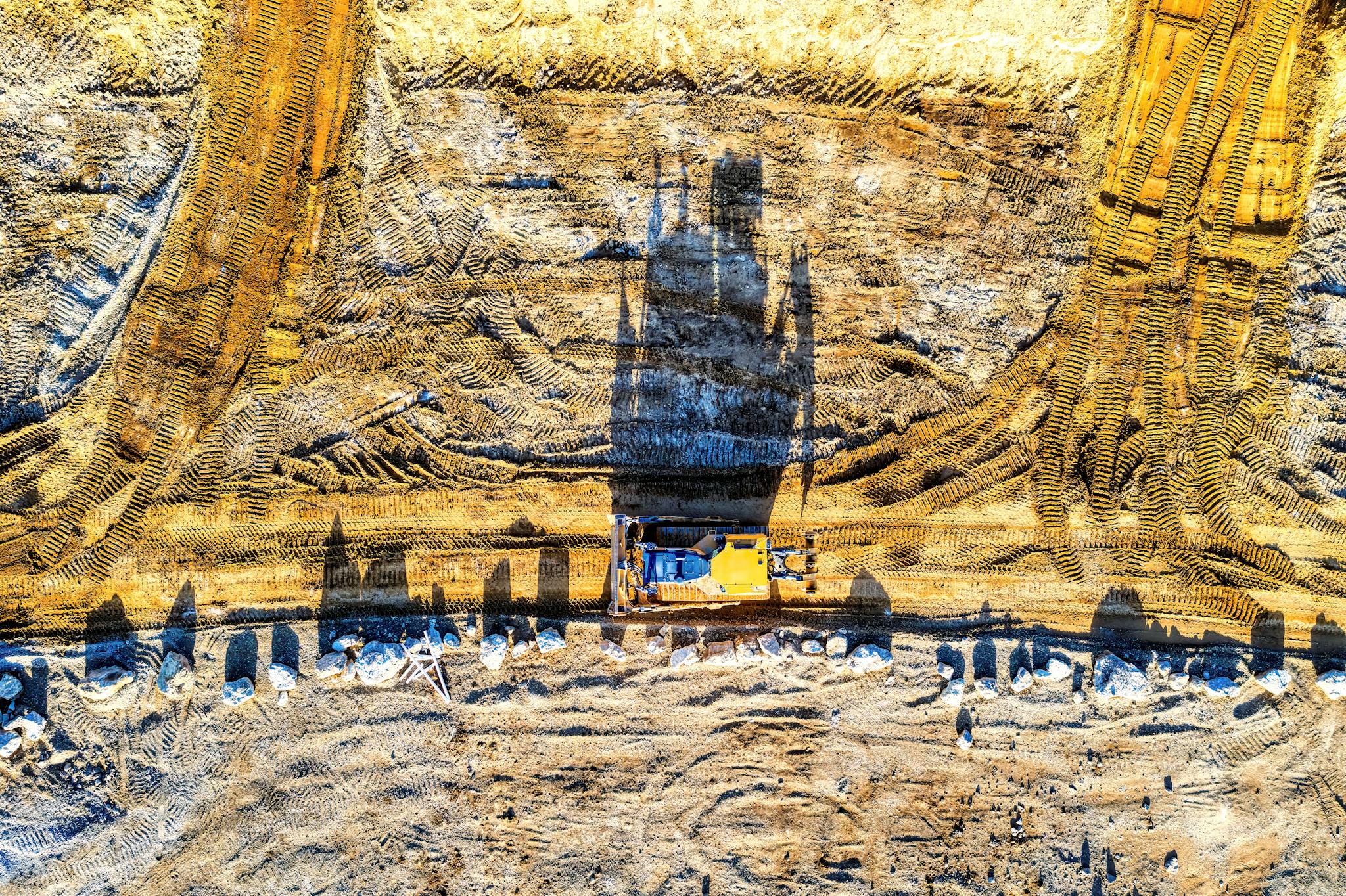 Top view of an excavator on a sunlit construction site in Rochester, MN.
